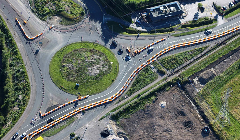 An aerial view of traffic management at a roundabout to create a safe working area